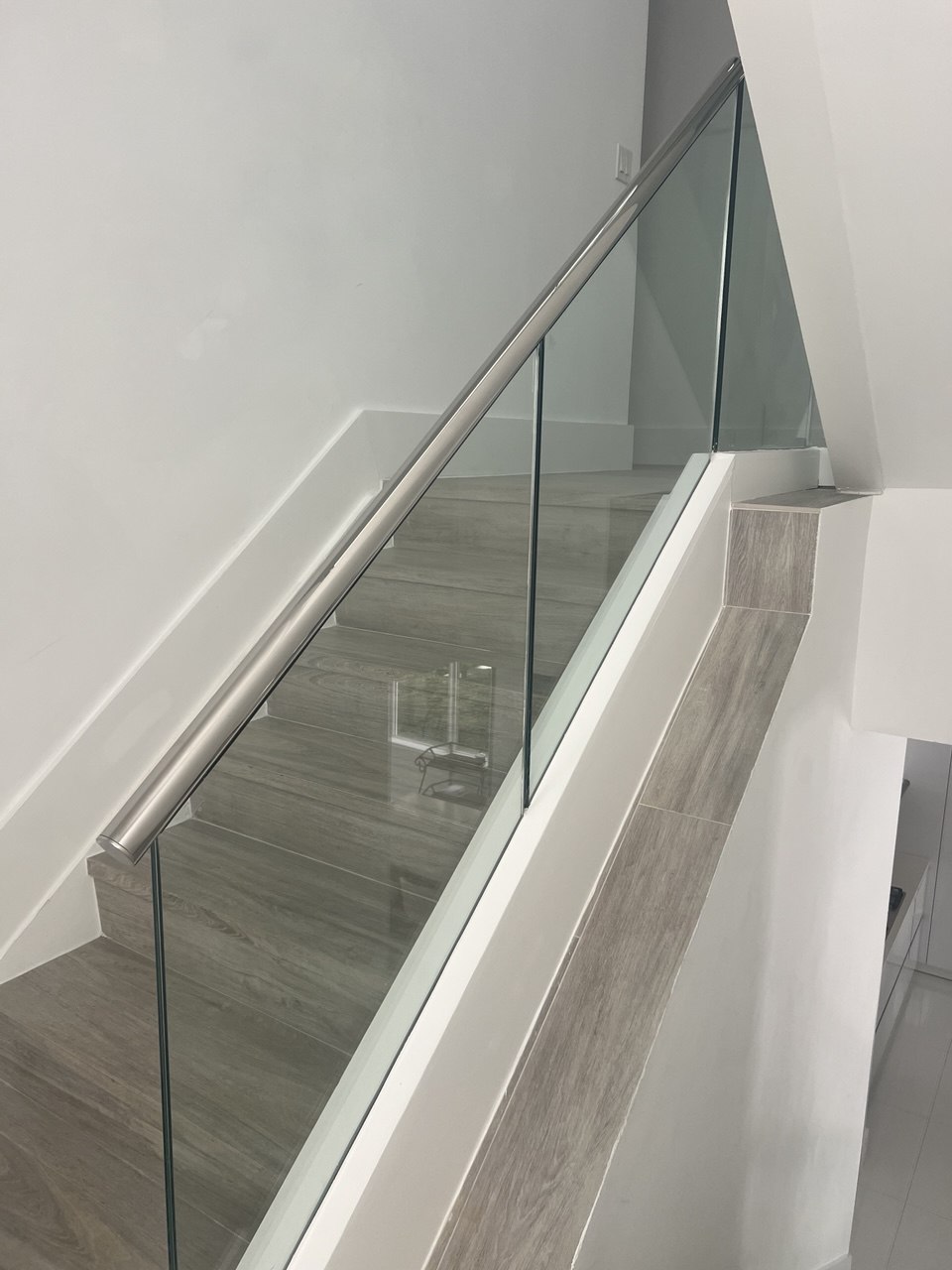 Glass stair railing installation in a modern home